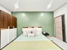 Spacious modern bedroom with green accent wall and stylish furniture