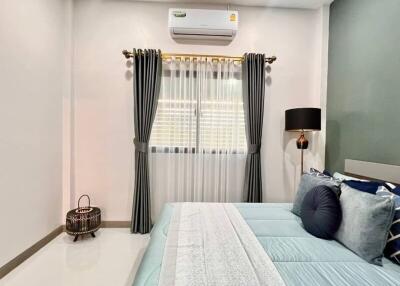 Well-decorated bedroom with a large bed, air conditioner, and modern furnishings