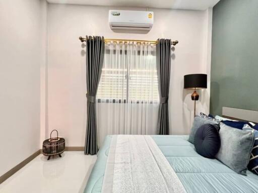 Well-decorated bedroom with a large bed, air conditioner, and modern furnishings