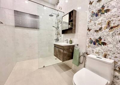 Modern bathroom with shower and butterfly-themed decor