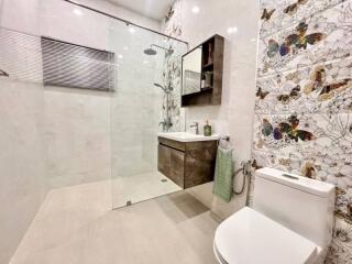 Modern bathroom with shower and butterfly-themed decor