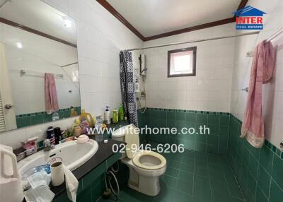 Bathroom with tiled walls and floor, basin, toilet, shower and window