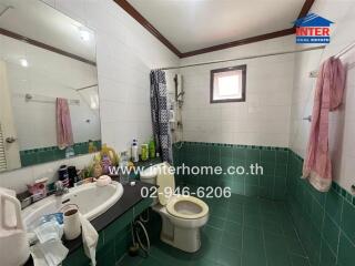 Bathroom with tiled walls and floor, basin, toilet, shower and window