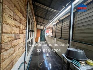 Covered outdoor area with storage and stone wall