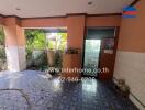 Covered outdoor area with tiles and garden view