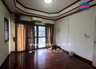 Renovated living room with wooden floors and balcony access