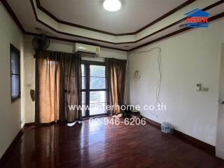 Renovated living room with wooden floors and balcony access