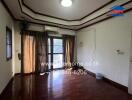 Renovated living room with wooden floors and balcony access