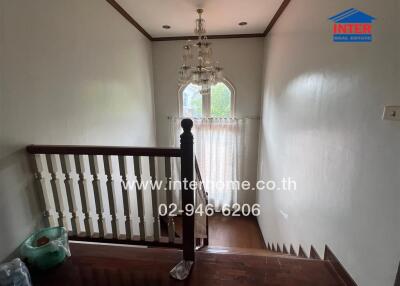 Staircase area with chandelier and window