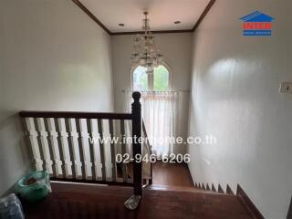 Staircase area with chandelier and window