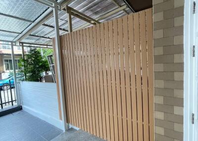 Modern covered patio with brick wall and wood fencing