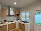 Modern kitchen with wooden cabinets, stovetop, and outdoor access