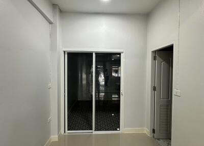 Small empty room with glass doors and hallway