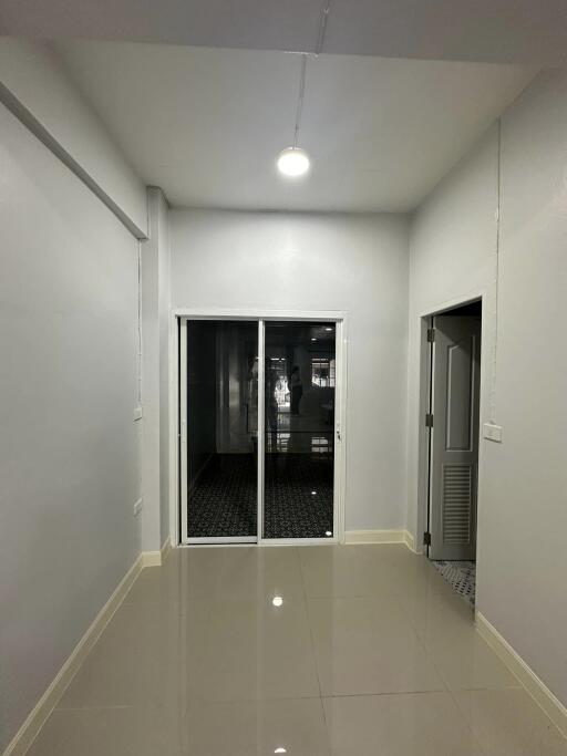 Small empty room with glass doors and hallway