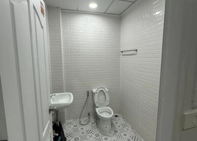 Bathroom with sink, toilet, and patterned tile floor