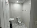 Bathroom with sink, toilet, and patterned tile floor