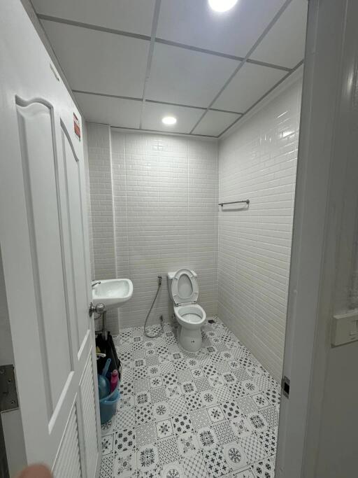 Bathroom with sink, toilet, and patterned tile floor