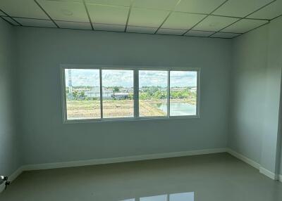 Empty bedroom with large window and tiled floor