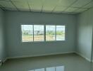 Empty bedroom with large window and tiled floor