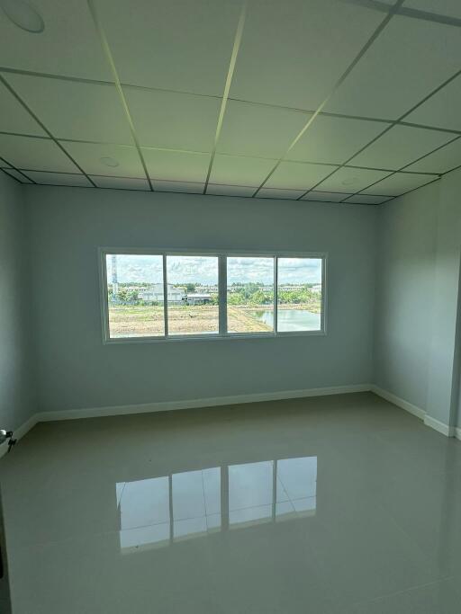 Empty bedroom with large window and tiled floor