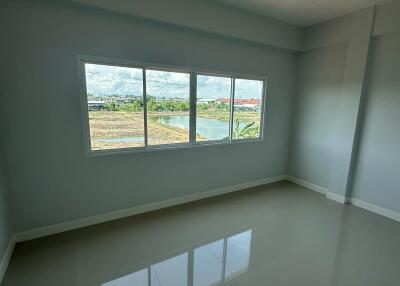 Empty bedroom with large window and tiled floor