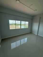 Empty bedroom with large window and tiled floor