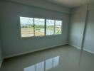 Empty bedroom with large window and tiled floor