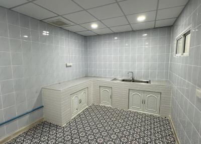 Tiled kitchen with sink and cabinets