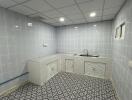 Tiled kitchen with sink and cabinets