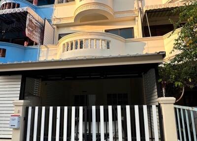 Front view of a multi-story townhouse with gated parking