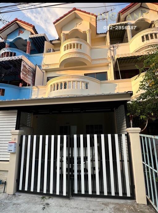 Front view of a multi-story townhouse with gated parking