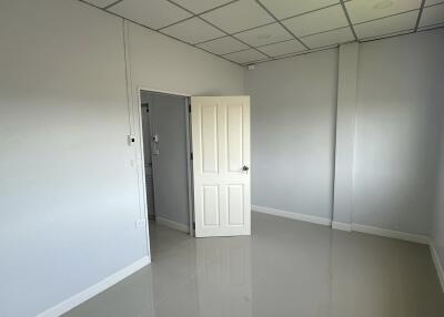 Spacious empty bedroom with tiled floor and door