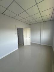 Spacious empty bedroom with tiled floor and door