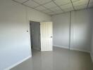 Spacious empty bedroom with tiled floor and door