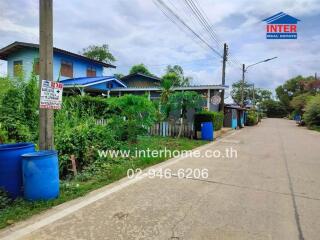 Street view of a residential area with houses and greenery