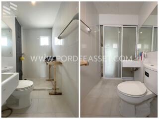 Modern bathroom with large mirror, white tiles, and glass shower partition