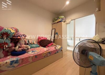 Bedroom with colorful bedding and plush toys