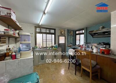 Kitchen with wooden cabinets, shelves, countertop appliances, and dining area