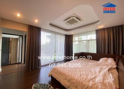 Spacious bedroom with large windows, air conditioning, and a comfortable bed