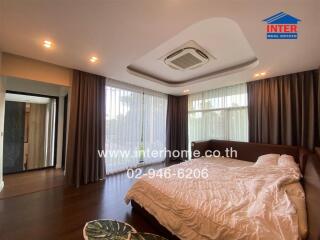 Spacious bedroom with large windows, air conditioning, and a comfortable bed