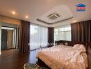 Spacious bedroom with large windows, air conditioning, and a comfortable bed