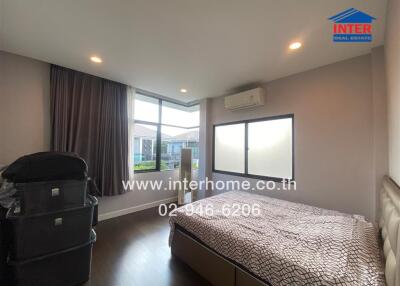 Bedroom with bed, air conditioner, large window, and stacked storage boxes.