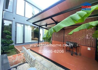 Outdoor covered patio with barbecue grill and plants