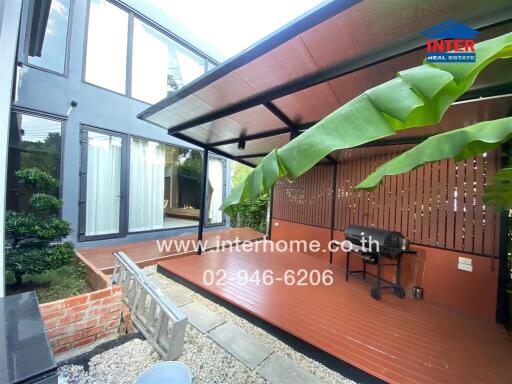 Outdoor covered patio with barbecue grill and plants