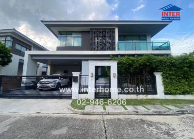 Front view of a modern two-story house with a driveway and a car parked