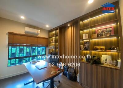 Modern home office with built-in wooden shelves and large window