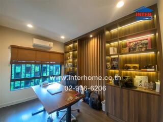 Modern home office with built-in wooden shelves and large window