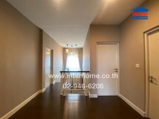 Spacious hallway with modern lighting and wooden flooring