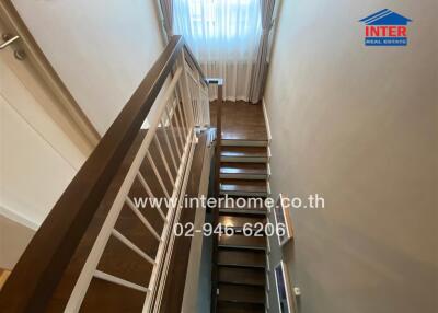 Indoor staircase with wooden steps and white railing