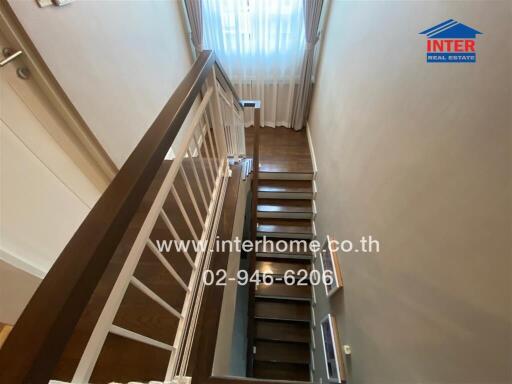 Indoor staircase with wooden steps and white railing